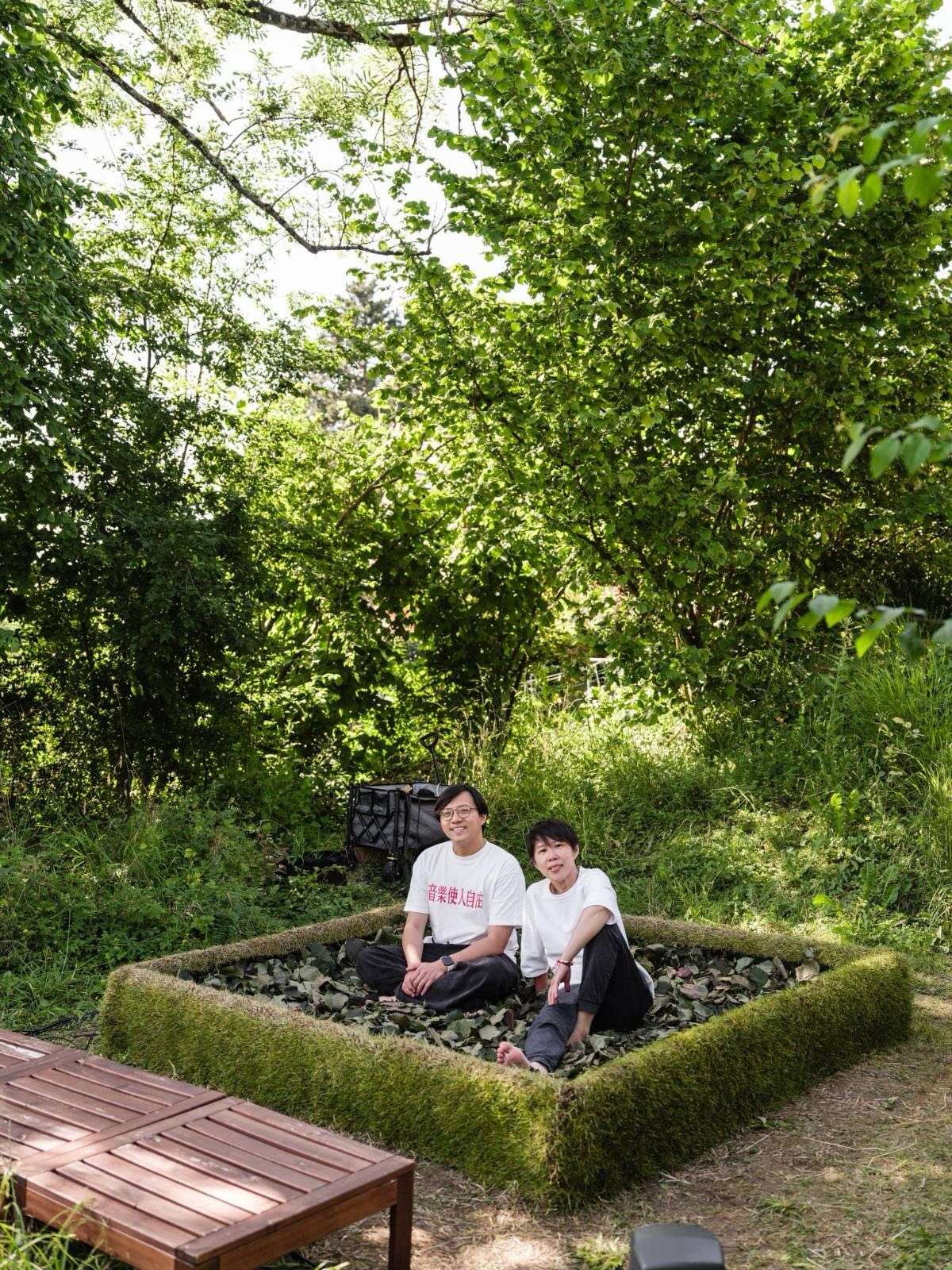 Two participants seated together on the bed of leaves