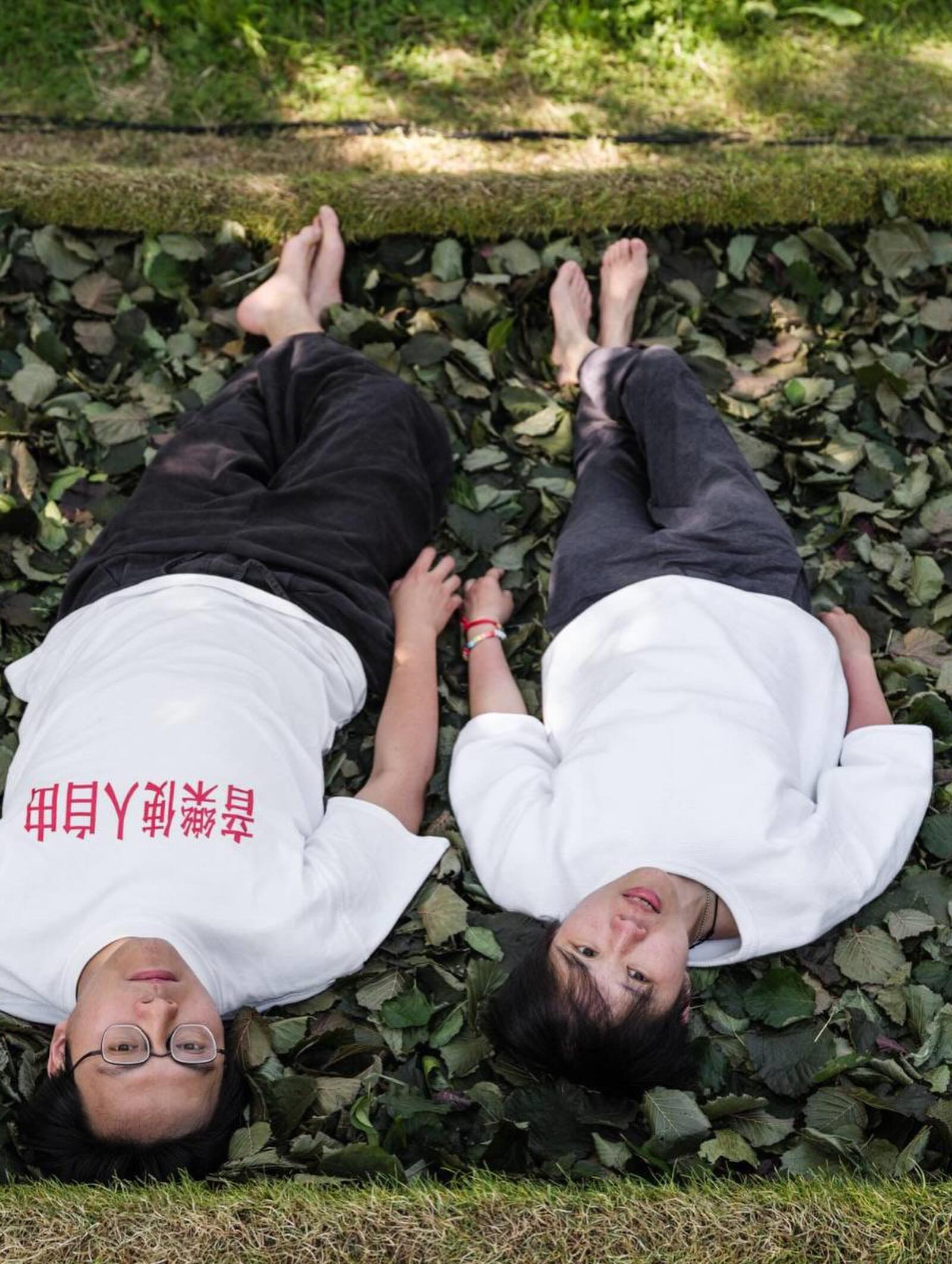 Two participants lying side by side on the leaves