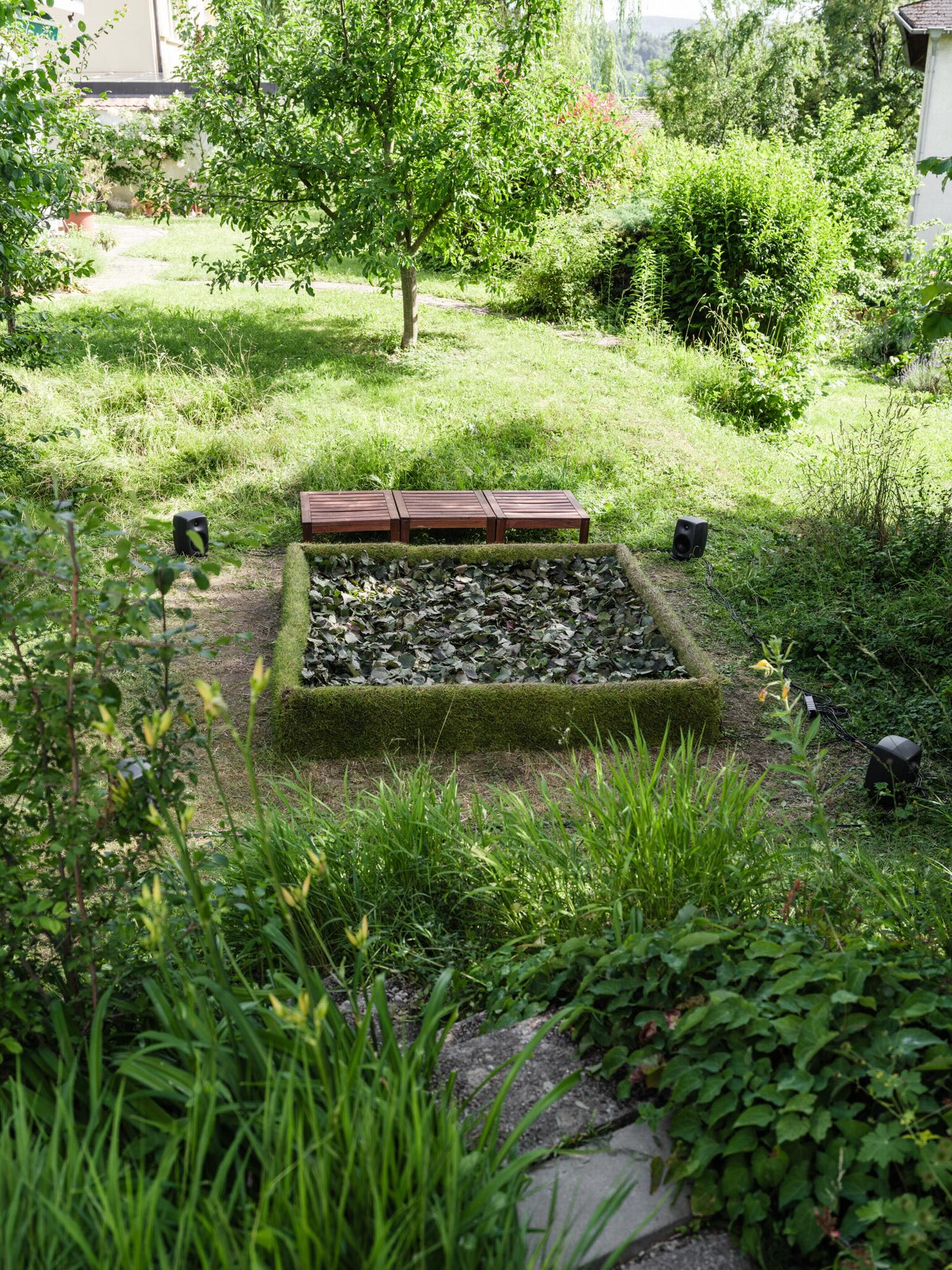 The leaf-filled installation and surrounding garden at PF25 Dornach Atelier